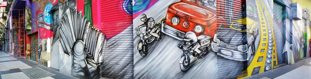 Panoramic street mural on metal shutters showing a red vintage car with motorcycle riders, colorful graffiti art on urban storefront in Buenos Aires