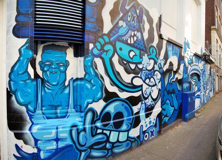 Blue-themed street art mural featuring cartoon monsters and Frankenstein character on Rotterdam building wall