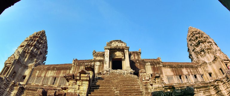 Stone temple entrance with two tower structures flanking a central staircase leading to a doorway, ancient Khmer architecture at Angkor Wat