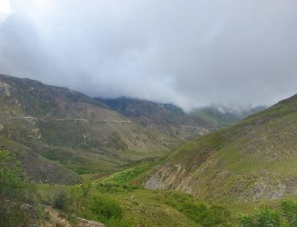 Mountain valley with winding road under low clouds in Salta, Argentina