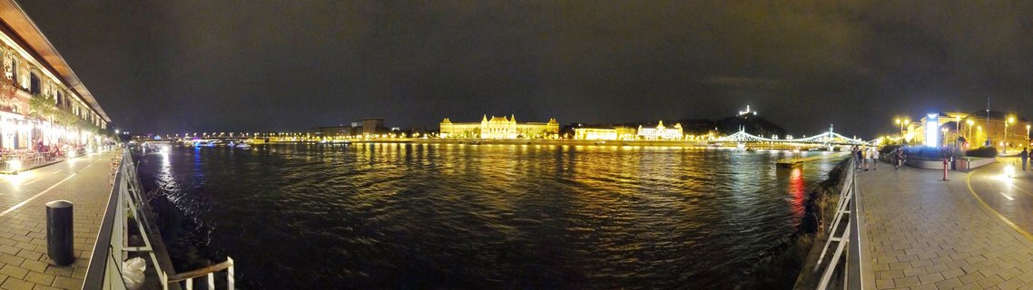 Panoramic night photograph of Budapest showing the illuminated Parliament Building, Elisabeth Bridge, and Danube River with light reflections on water