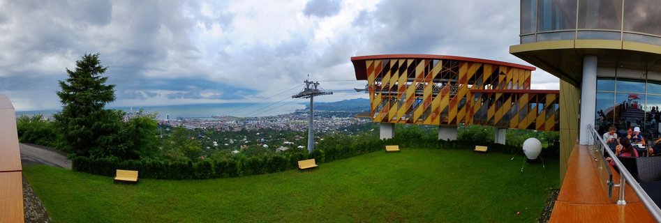 Cable car station with yellow geometric building overlooking Batumi city and Black Sea from mountain viewpoint