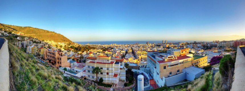 Golden hour illuminates hillside homes overlooking Atlantic Ocean in Tenerife, Canary Islands, Spain