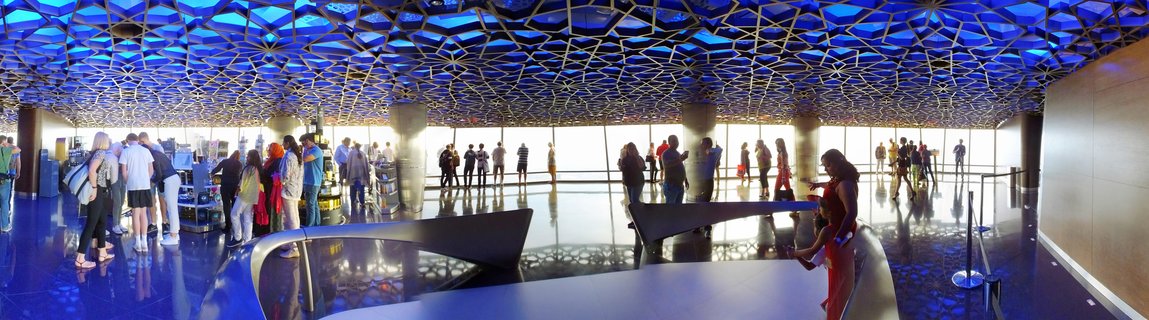 Interior view of Museum of the Future observation deck in Dubai showing visitors beneath an illuminated blue geometric patterned ceiling with reflective floors and large windows