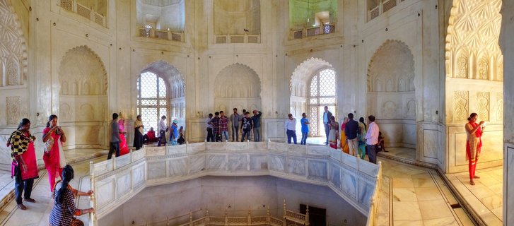 Interior view of Bibi Ka Maqbara showing white marble gallery with ornate railings, arched jali windows, decorative wall panels, and visitors exploring the 17th-century Mughal mausoleum in Aurangabad, India