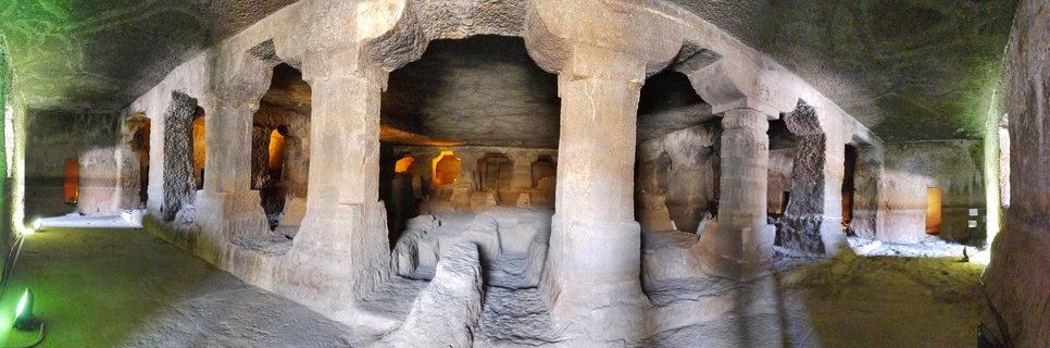 Interior of ancient cave temple with carved stone pillars and chambers in Aurangabad, India
