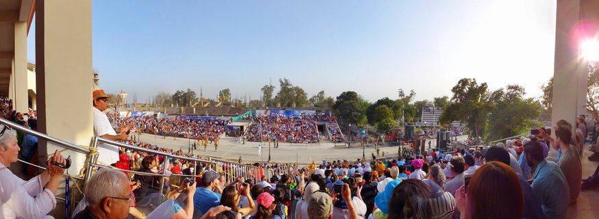 Large crowd of spectators watching soldiers perform ceremonial border closing ritual at Wagah Border crossing between India and Pakistan