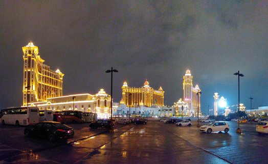 Galaxy Macau Resort Complex Illuminated at Night with Wet Pavement Reflections