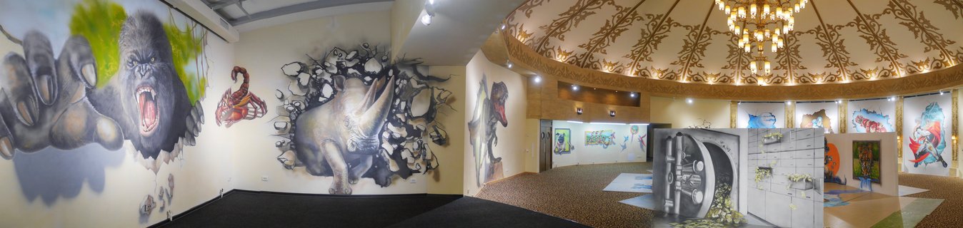 Interior view of a room with walls and ceiling covered in black and white zebra stripe optical illusion murals, with swirling patterns and zebra illustrations, fluorescent ceiling lights, open wooden door, and gray carpeted floor