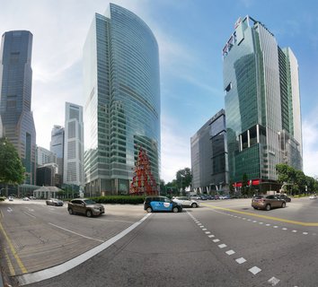 Street-level view of Singapore CBD showing multiple glass skyscrapers, a red sculptural installation, cars at intersection, blue sky with clouds
