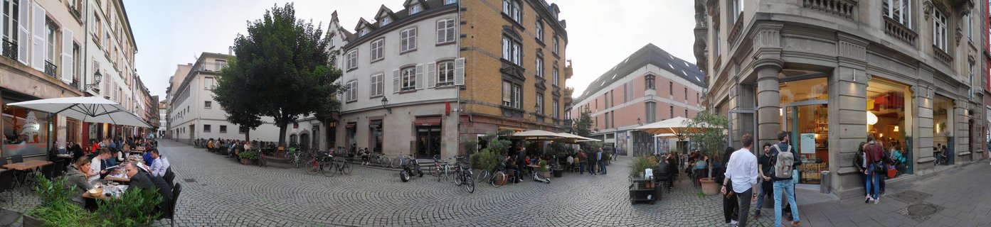 Evening street scene with outdoor dining in historic Strasbourg city center, France