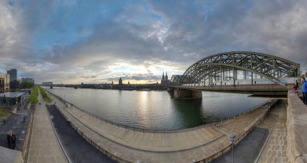 Cologne Cathedral and Hohenzollern Bridge over Rhine River at sunset, Germany