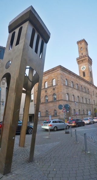 Modern sculpture stands before historic Fürth City Hall clock tower in Bavaria, Germany